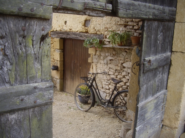 Dans la cour, un vieux vélo. - Auriac-du-Périgord