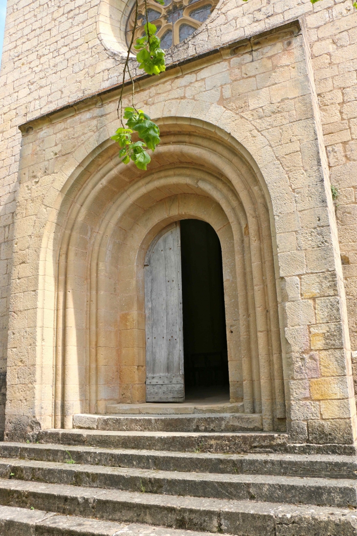 Eglise Notre Dame sous Biron : portail en plein cintre à trois voussures. Portail sumonté d'une rose.