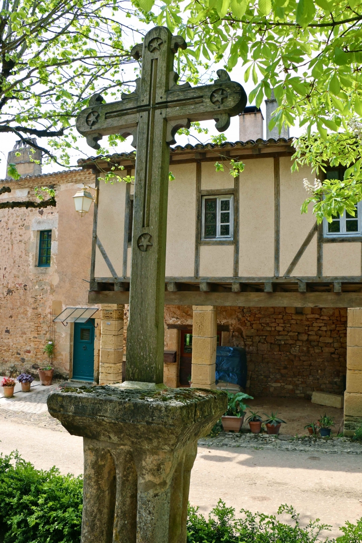 Croix en bois sculpté, devant le parvis de l'église Notre dame sous Biron.