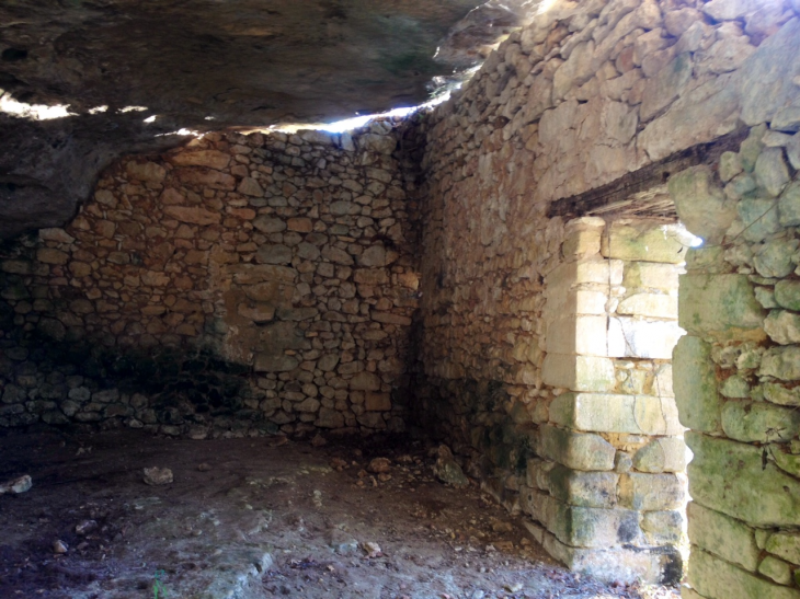 Intérieur d'une construction ancienne appuyée sur la paroi rocheuse et en partie creusée dans celle-ci. - Mauzens-et-Miremont