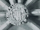 Clef de voûte intéressante : à l'intérieur d'une couronne tressée, se dressent deux personnages qui tiennent un écusson surmonté de trois fleurs de lys et orné du monogramme IHS - Eglise Saint Martin d'Esperous (photographie 1980, églises ancienne du Gar