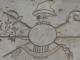 Figure allégorique gravée sur la pierre de la Bastille. Les trois fleurs de lys du médaillon central ont été martelées, la crosse,l'épée et la faux évoquent le clergé, la noblesse et le tiers état unis à l'assemblée national. 