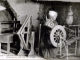 Assise au coin du feu, la ménagère habile et fait tourner son rouet d'une main fort agile, vers 1904 (carte postale ancienne).