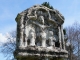 Détail : Petit édifice religieux à fronton et arcatures polylobées, sculptés d'un Calvaire