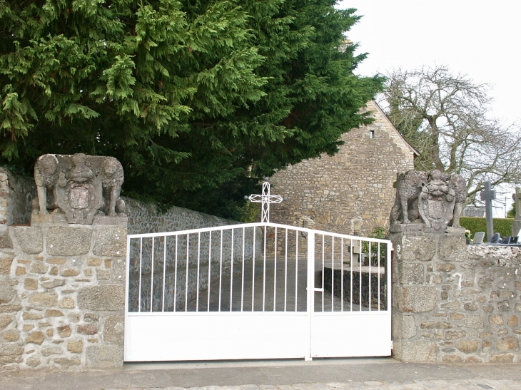 Sur les deux piliers du portail d'entrée du cimetière se dressent deux blocs de marbre identiques, sculptés d'amoiries entourées du collier de Saint Michel et soutenues par deux lions accroupis. - Alexain