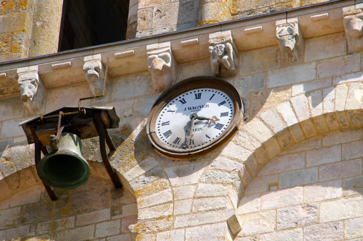 La cloche, l'horloge et les modillons du clocher de l'Abbatial. - Saint-Savin