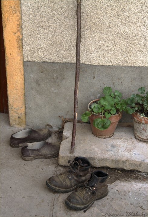 Devant l'humble maison, les chaussures se reposent après le labeur... - Saint-Loup