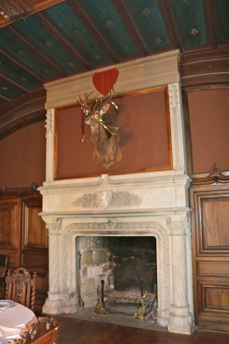 Le château de Bridoire : la salle à manger,  cheminée en pierre du XIXe siècle aux armes de la Famille de Foucault - Ribagnac