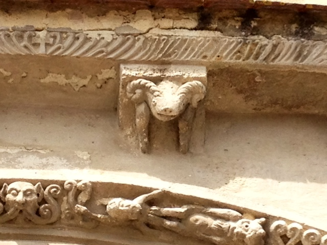 Modillon sculpté au dessus de portail de l'église Saint Romain. - Targon