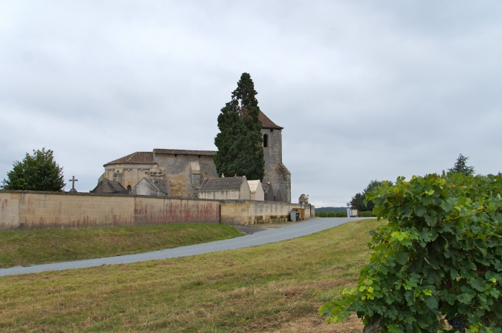 Eglise Notre Dame. Située au sommet d'un coteau qui domine un paysage de vignes et entourée de son cimetière clos de murs de pierre. - Tayac