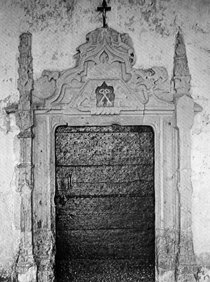 Portail de pierre du XVe ou XVIe siècle, encadré par deux pinacles, surmonté d'un gâble trilobé orné de végétaux (photo 1980, eglises anciennes du Gabardan). - Lubbon
