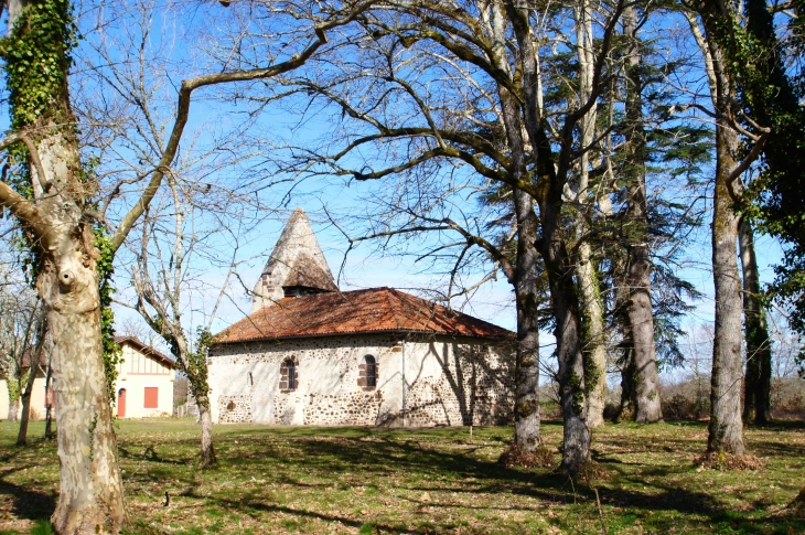 L'église Saint-Pierre s'élève dans le cadre particulièrement remarquable d'un large airial de chênes ouvert dans la forêt de pins. - Lubbon