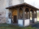 En avant de la façade occidentale qui forme clocher-mur, un porche grâcieux fait de bois et de maçonnerie abrite un portail du XVe ou du XVIe siècle, qui constitue l'élément le plus original de l'ensemble (photo 2013).