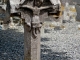 Photo suivante de Saint-Hippolyte Croix de Ribetrolles du XVe siècle. Le Christ a les bras peu levés et la tête penche à gauche. Le sigle INRI est inscrit en lettres gothiques. Sous les bras en lit mal deux motifs que des spécialistes pensent être le phénix et la salamandre.