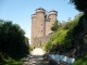 Photo précédente de Tournemire C'est une forteresse d'aspect martial composée d'un haut donjon cantonné de quatre grandes tours coiffées de mâchicoulis. Elle a été construite en pierre de lave sur un éperon qui domine la vallée encaissée de la Doire