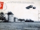 Le premier voyage en aéroplane - Du camp de Châlons à Reims 30 octobre 1908, M. Henri Farman passant au-dessus du Moulin de Mourmelon (carte postale ancienne).