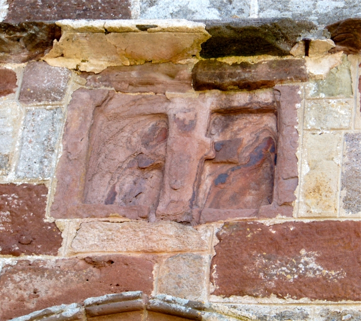 Pierre sculptée au dessus du portail de l'église Saint-Eutrope. - Beyssac