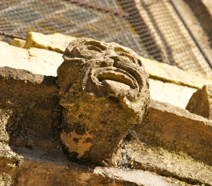 Tête sculptée au dessus du portail de l'église. - Perpezac-le-Blanc
