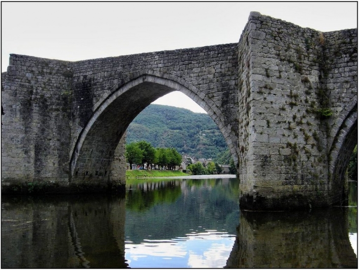 Vue d'Entraygues à travers une arche du vieux pont sur la Truyère - Entraygues-sur-Truyère