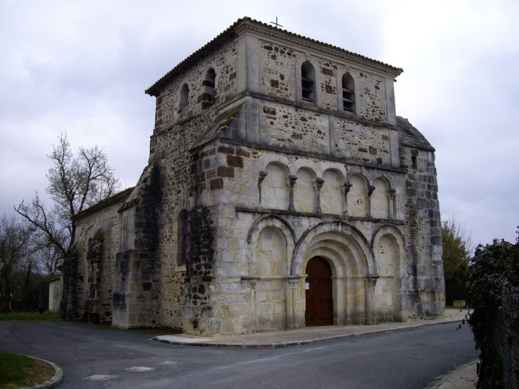 Eglise Notre Dame de l'Assomption, bâtie en grison, et son portail de style saintongeais. - Bussac-Forêt