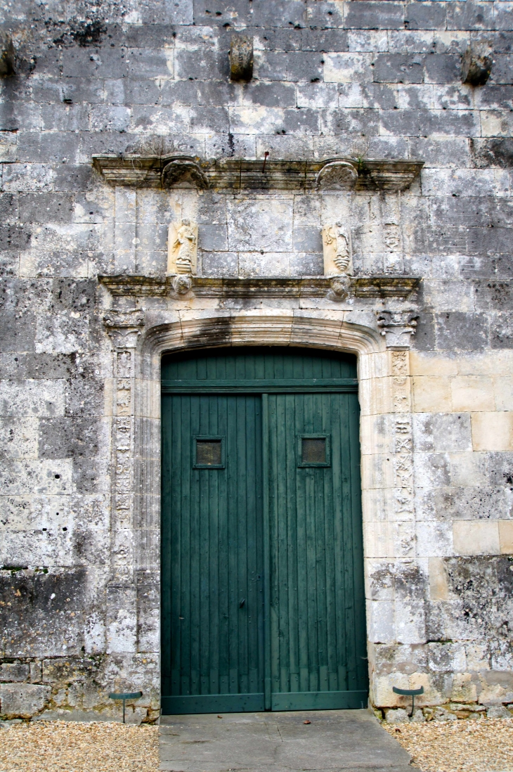 La porte moulurée à linteau de la façade renaissance est surmontée d'un décor sculpté à pilastre orné. des statues, notamment un Christ et les évangélistes de l'ancien tympan ont été ajoutés à la maçonnerie - Eglise Saint André. - Clion