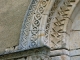 Détail : chapiteau, frise et archivolte scultés du portail de l'église du XIIe siècle.