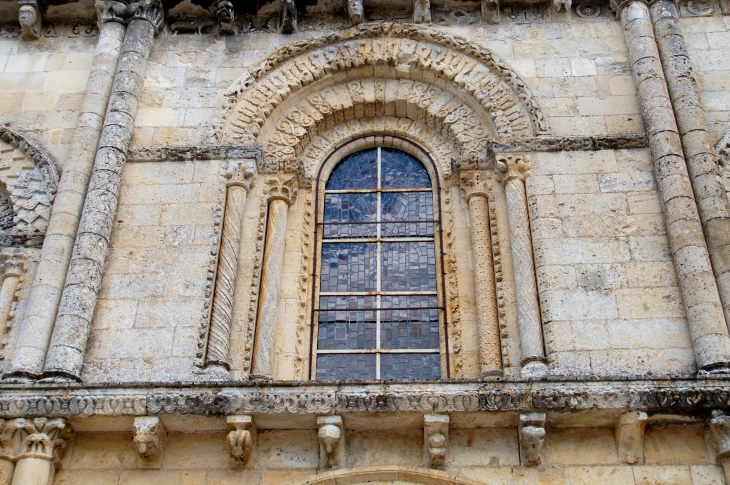 Détail : fenêtre en plein cintre richement décorée. Façade occidentale de l'église Sainte Hilaire. - Melle