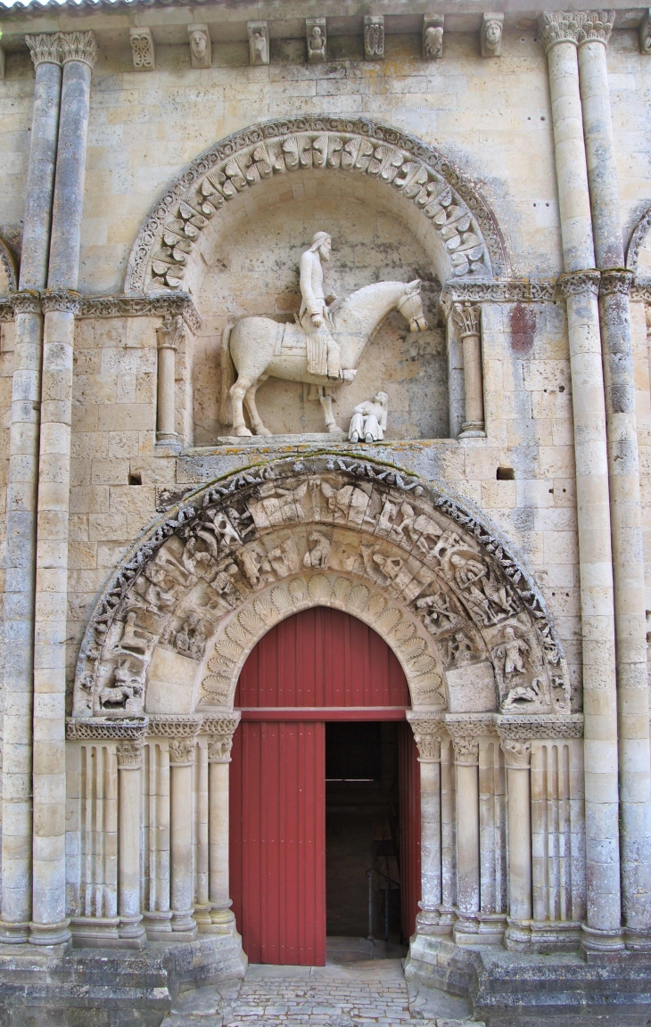 L'église Saint Hilaire : Le portail du mur latéral nord se distingue par ses sculptures. Le cavalier en haut relief, dans une niche, symboliserait la victoire de Constantin 1er sur les païens, surmonte la représentation du combat des vices et des vertus,  - Melle