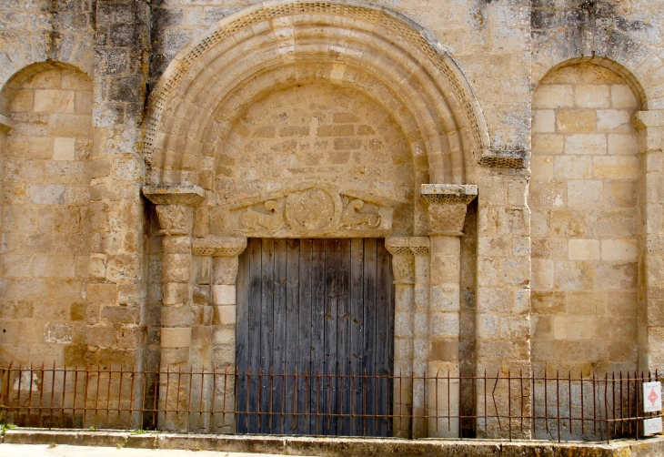 Eglise Saint Savinien offre un portail encadré de deux arcatures aveugles. Le tympan du portail est en forme de batière, décor fort répandu en Auvergne mais rare en poitou. - Melle