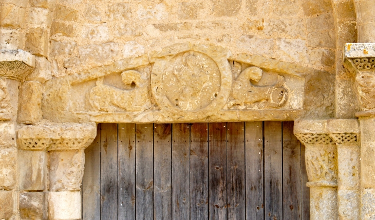 Eglise Saint Savinien. Les sculptures en faible relief montrent un Christ cerclé dans un médaillon, debout entre deux lions. - Melle