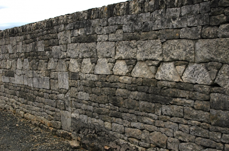 Mur du cimetière constituée d'anciennes pierres tombales retaillées formant une frise  - Saint-Médard